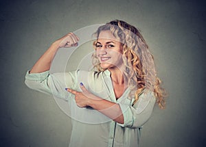 Young happy woman flexing muscles showing her strength