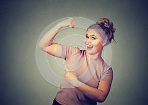 Young happy woman flexing muscles showing her strength. Weight loss concept