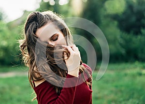 Young happy woman with fluttering hair have fun outdoors on green summer nature background