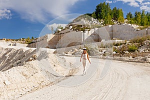 Young happy woman with glasses and hat running on the road in summer