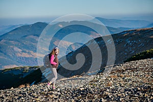 Young happy woman hiker is walking on mountain plato