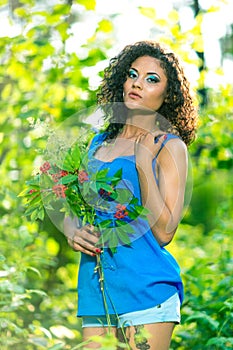 Young happy woman holding big bouquet of spring flowers outdoors