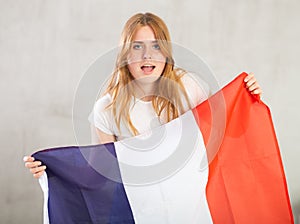 Young happy woman holding flag of French with happy face and smiling