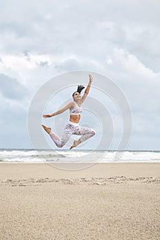 Young happy woman jumping on the beach