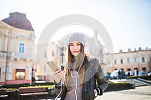 Young happy woman, listening music and having fun on the street Outdoor.