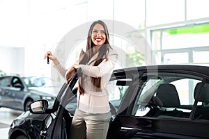 Young happy woman near the car with keys in hand - buying new car