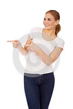 Young happy woman pointing for copyspace or something