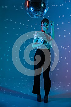 Young happy woman posing  with disco ball lights