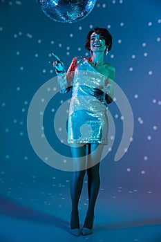 Young happy woman posing  with disco ball lights