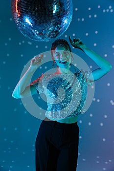 Young happy woman posing isolated with disco ball lights