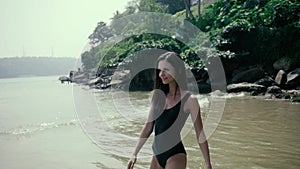 Young happy woman posing and running on the beach , happy tourist near ocean