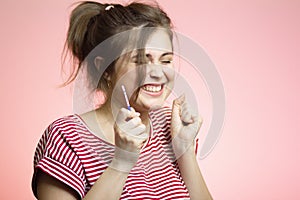Young happy woman with positive result result of a one-time pregnancy test, excited future mother, family planning, motherhood