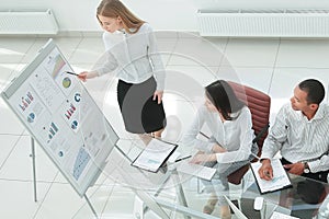 Young happy woman presenting her idea to colleagues at meeting