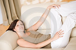 Young happy woman relax lying down on sofa