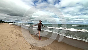 Young happy woman running on a beach