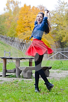 Young happy woman in short red skirt spinning around