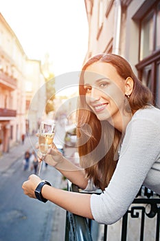 Young happy woman standing with glass of champagne