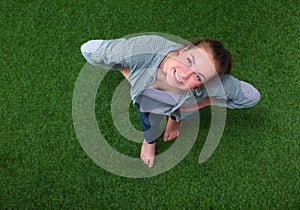 Young happy woman standing in green grass