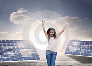 A young happy woman stands with her hands in the air