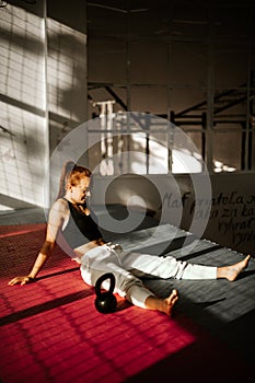 Young happy woman after Strength Training sitting on the ground. woman full of endorphins. vertical photo