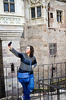 Young happy woman taking a selfie at Corvin Castle, Romania