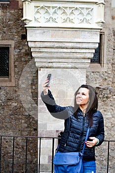 Young happy woman taking a selfie at Corvin Castle, Romania