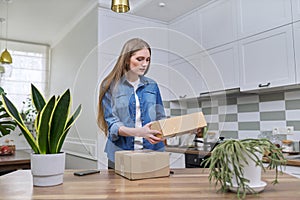 Young happy woman unpacking cardboard boxes, unboxing expected postal parcel