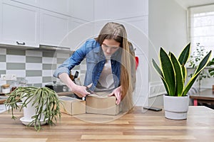 Young happy woman unpacking cardboard boxes, unboxing expected postal parcel