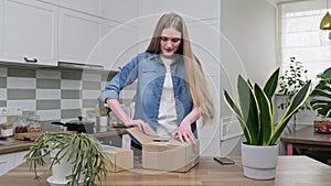 Young happy woman unpacking cardboard boxes, unboxing expected postal parcel