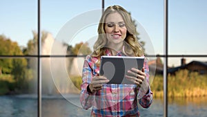 Young happy woman using portable digital tablet.