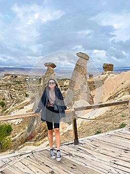 Young happy woman on vacation in Cappadocia. Cave formations.