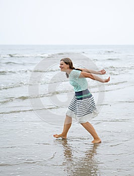 Young happy woman walking on the beach of St.Peter Ording, North