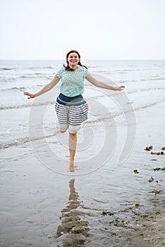 Young happy woman walking on the beach of St.Peter Ording, North