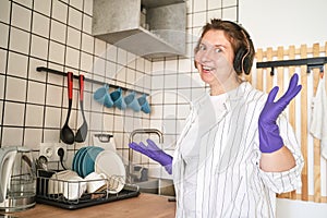 Young happy woman wash dishes at kitchen. Bright female portrait. Wow emotion