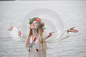 Young happy woman wearing tradisional closes and wreath