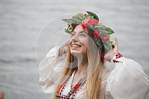 Young happy woman wearing tradisional closes and wreath