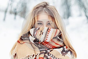 Young happy woman wearing winter cloth. Scarf on the face