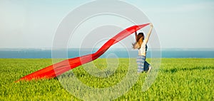 Young happy woman in wheat field with fabric