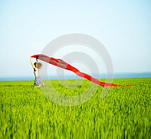 Young happy woman in wheat field with fabric