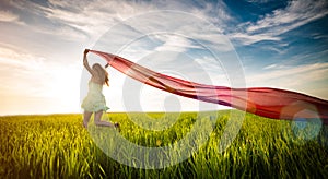 Young happy woman in wheat field with fabric