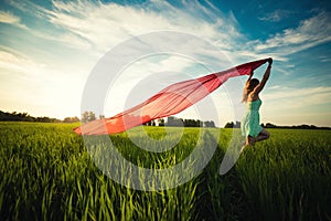 Young happy woman in wheat field with fabric. Summer lifestyle