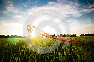 Young happy woman in wheat field with fabric. Summer lifestyle