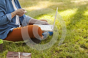 Young happy woman working with her laptop sitting on the pier, relaxing to enjoy with nature.