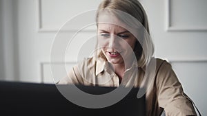 Young and Happy woman working at the laptop computer and laughing. Fashion girl having fun during shopping online