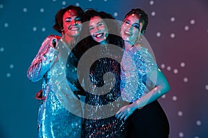 Young happy women posing isolated with disco ball lights