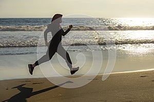 Young healthy and active runner Muslim woman in Islam hijab head scarf running and jogging on the beach wearing traditional arab