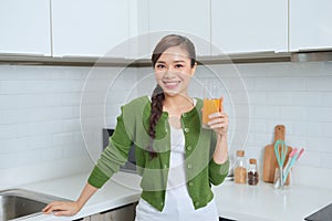 Young healthy asian woman drinking orange juice
