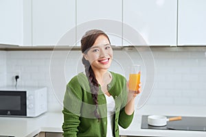 Young healthy asian woman drinking orange juice