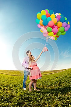 Young healthy beautiful pregnant woman with her husband and ball