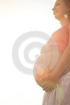 Young healthy beautiful pregnant woman outdoors. A girl with a t